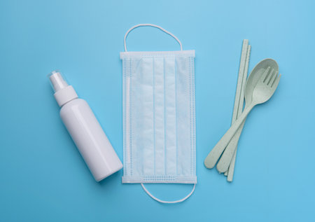 Personal accessory with face mask  white hand sanitizer or alcohol gel and green spoon set protection from coronavirus on blue backgroundsの写真素材