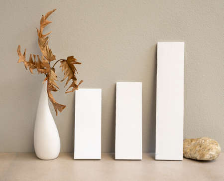 Mock up invitation white cards and exotic Philodendron dry leaves in modern vase on marble table with concrete background,greeting card in earth tone still lifeの写真素材