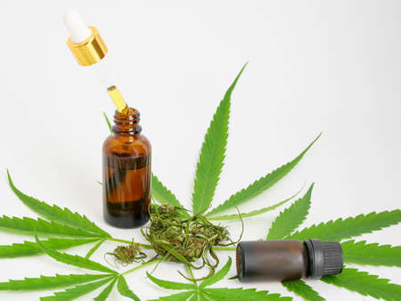 Glass bottle CBD oil cannabis extract marijuana leaf and bud on white background , Medical herb concept.の写真素材
