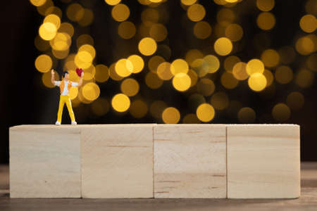 Miniature people man holding red heart for lover with light bokeh background,Valentines conceptの写真素材