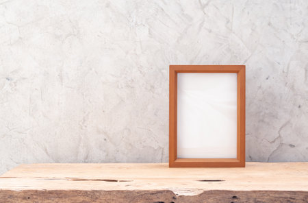 Teak wood frame mock up on table  with loft cement wall background,space for products