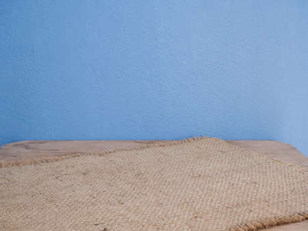 Sackcloth,burlap hessian  arrange on wooden table and blue cement wall background  with copy spaceの写真素材