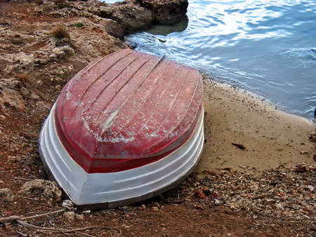 Lonelhy red boat resting in the seashore                                                         の写真素材