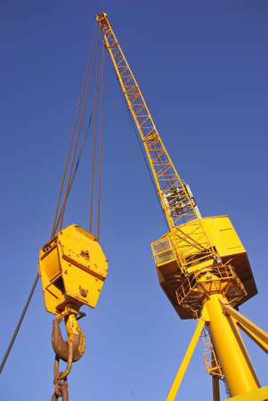 Yellow industrial crane on a cargo dockの写真素材