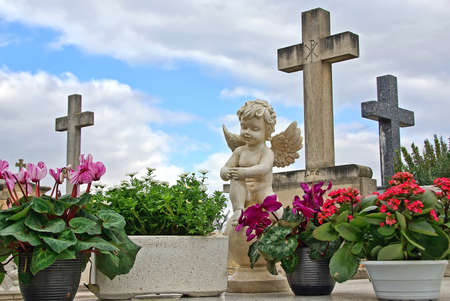 Statue of an angel boy located in a cemeteryの写真素材