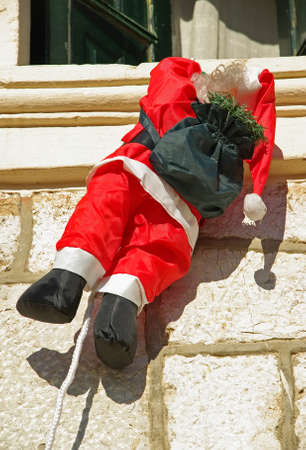 Santa Claus climbing a wall in Christmasの写真素材