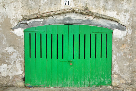 Wooden green door of a boat shelter in Majorcaの写真素材
