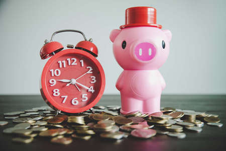 Pink piggy bank on table with coins, Business or finance saving concept