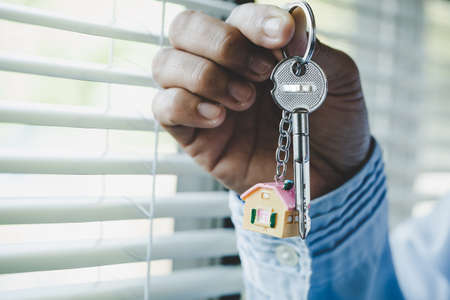 Real estate agent handing over a house key, concept for real estate, moving home or renting property