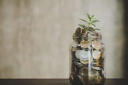 Savings deposit coins in a clear glass bottle.