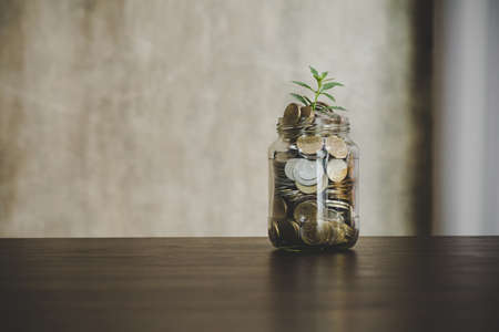 Savings deposit coins in a clear glass bottle.