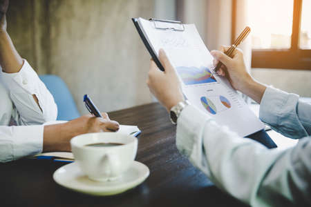 Business colleagues working and analyzing financial figures on a graphsの写真素材