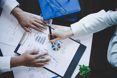 Business colleagues working and analyzing financial figures on a graphsの写真素材