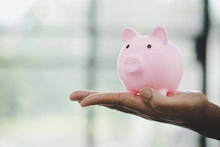 woman hand holding piggy bank for saving money wealth and financial concept.の写真素材