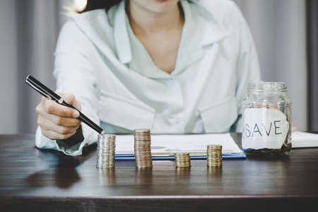 Female hand with money coin stack growing business for saving money wealth and financial concept.の写真素材