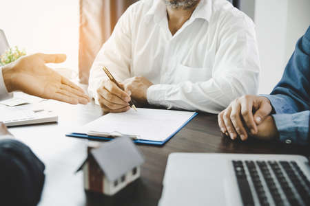 Real estate agent talked about the terms of the home purchase agreement and asked the customer to sign the documents to make the contract legally, Home sales and home insurance concept.の写真素材