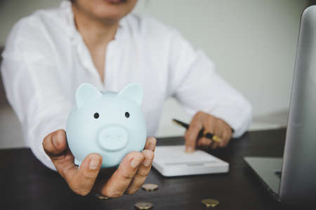 woman hand holding piggy bank for saving money wealth and financial concept.の写真素材