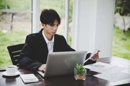Businessman looking at charts, spreadsheets, graph financial development, bank accounts, statistics, economy, data analysis, investment analysis, stock exchangeの写真素材