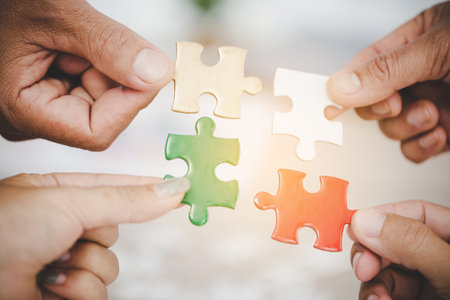 Hands holding piece of blank jigsaw puzzle for teamwork workplace success and strategy concept.の写真素材