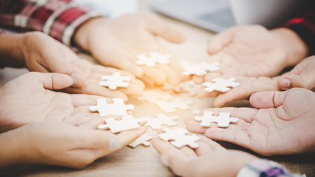 Business people and puzzle on wooden table, teamwork conceptの写真素材