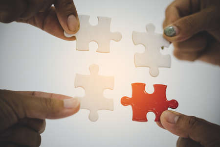 Group of business people assembling jigsaw puzzle and represent team support and help conceptの写真素材