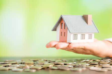Model house on coins, Savings money for buy house and loan to business investment for real estate concept.の写真素材