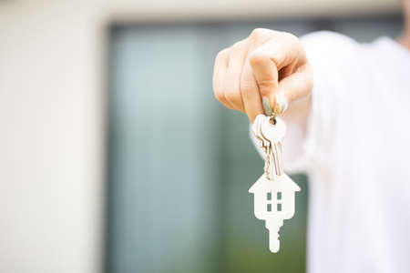Close up portrait hand of asian woman hold show keys in new house. estate and property conceptの写真素材