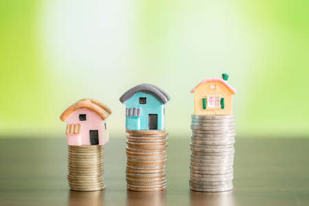 Miniature colorful house on stack coins, Savings money for buy house and loan to business investment for real estate concept.の写真素材