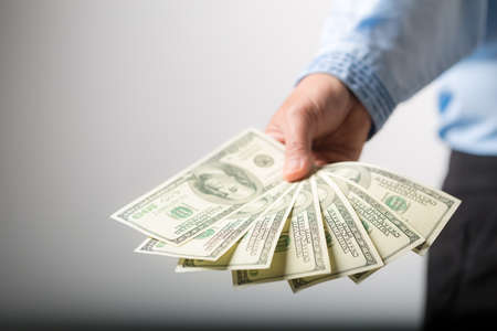 Close up of woman hand holding 100 dollar bills. success business female happy with many money banknote. Finance and economics concepts.の写真素材