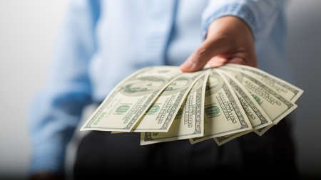 Close up of woman hand holding 100 dollar bills. success business female happy with many money banknote. Finance and economics concepts.の写真素材