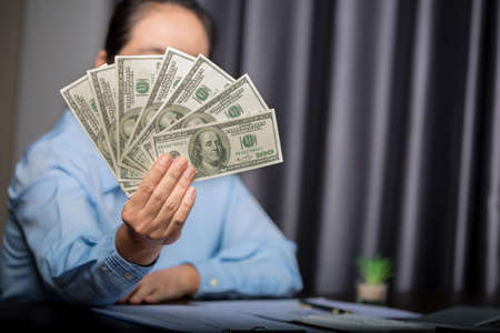 Close up young business woman using counting cash money one hundred dollar bills, checking financial...