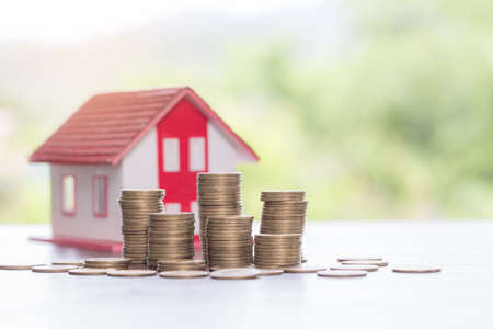 House model and money coins stacks with blur nature background. Savings plans for home, loan, investment, mortgage, finance and banking about house concept.の写真素材