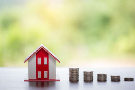 House model and money coins stacks with blur nature background. Savings plans for home, loan, investment, mortgage, finance and banking about house concept.の写真素材