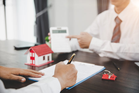 Real estate agents offer contracts to purchase or rent residential. Business person hands holding home model, small building red house. Mortgage property insurance moving home and real estate conceptの写真素材