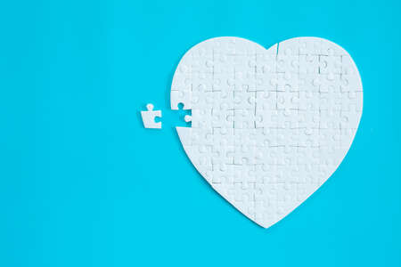 White heart shape of jigsaw puzzle pieces on blue background. concepts of problem solving, business success, teamwork, Team playing jigsaw game incomplete, Texture banner with copy space for textの写真素材