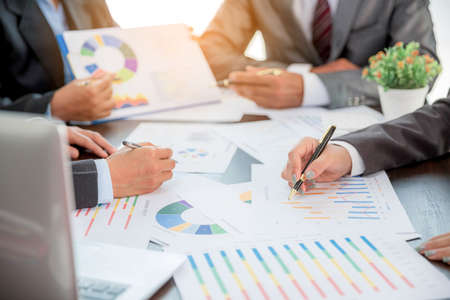Group professional business people person working together to analyze in office, work together to discuss company financial statistics report, brainstorm ideas, and graph datum documents on the table.の写真素材