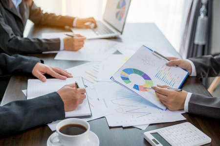 Group professional business people person working together to analyze in office, work together to discuss company financial statistics report, brainstorm ideas, and graph datum documents on the table.の写真素材
