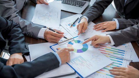 Group professional business people person working together to analyze in office, work together to discuss company financial statistics report, brainstorm ideas, and graph datum documents on the table.の写真素材