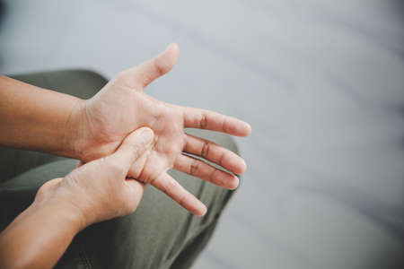 Arthritis person, finger woman ache from working in office. Concept office syndrome hand pain from occupational disease, woman having wrist pain from using laptop computer, wrist pain.の写真素材