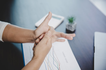 Arthritis person, finger woman ache from working in office. Concept office syndrome hand pain from occupational disease, woman having wrist pain from using laptop computer, wrist pain.の写真素材