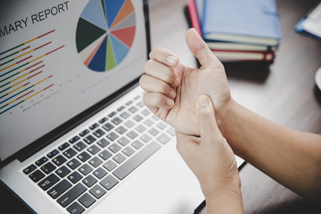 Arthritis person, finger woman ache from working in office. Concept office syndrome hand pain from occupational disease, woman having wrist pain from using laptop computer, wrist pain.の写真素材