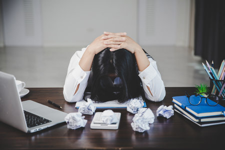 Stress business woman person from hard work, depression in office. Tired and anxious employee female with unhappy at problem job. young businesswoman sitting sad front of laptop computer on desk.の写真素材