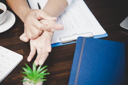 Arthritis person, finger woman ache from working in office. Concept office syndrome hand pain from occupational disease, woman having wrist pain from using laptop computer, wrist pain.の写真素材