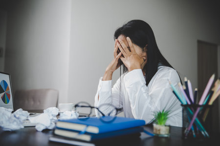 Stress business woman person from hard work, depression in office. Tired and anxious employee female with unhappy at problem job. young businesswoman sitting sad front of laptop computer on desk.の写真素材