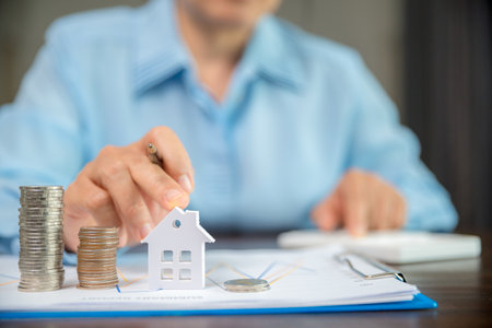 Model house and stack money coins to save for residential. Cash financial plan for loans or mortgages and investments with bank. Concept for house insurance business with tax and real estate growthの写真素材