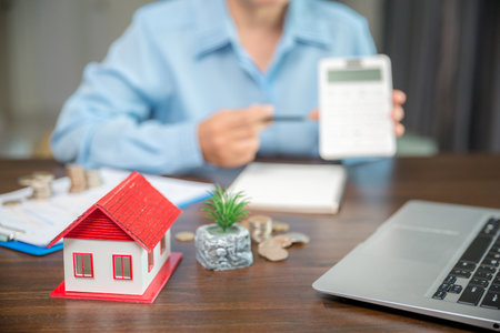 Model house and stack money coins to save for residential. Cash financial plan for loans or mortgages and investments with bank. Concept for house insurance business with tax and real estate growthの写真素材