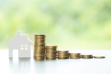 House and stack money coins with background to save for residential. Cash financial plan for loans or mortgages and investments with bank. Concept for house insurance business and real estate growthの写真素材