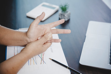 Arthritis person, finger woman ache from working in office. Concept office syndrome hand pain from occupational disease, woman having wrist pain from using laptop computer, wrist pain.の写真素材