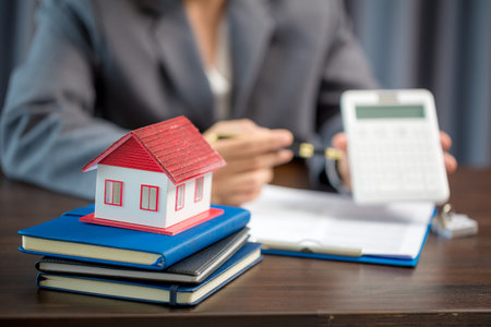 Woman home sales person is checking documents for house purchase contract before letting the customer sign contract on table is key with house model, real estate trading and insurance property conceptの写真素材