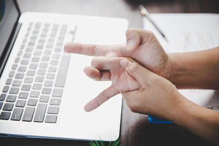 Arthritis person, finger woman ache from working in office. Concept office syndrome hand pain from occupational disease, woman having wrist pain from using laptop computer, wrist pain.の写真素材